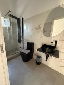 a bathroom with a black sink and a shower at Coconut beach villas 5 in Schinias