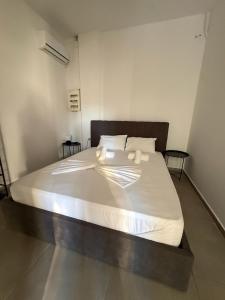 a bedroom with a large bed with white sheets and pillows at Coconut beach villas 5 in Schinias