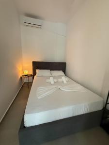 a bedroom with a white bed with two pillows at Coconut beach villas 5 in Schinias