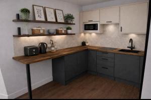 a kitchen with a counter with a sink and a microwave at A1 HighTown Aprtmnt, Steps frm Luton Train Station in Luton