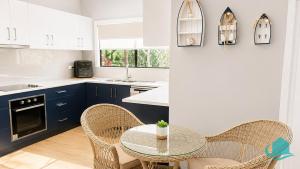 a kitchen with blue cabinets and a table and chairs at Castaway at Pelican in Pelican Flat