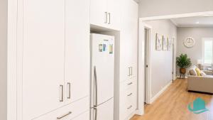 a kitchen with white cabinets and a refrigerator at Castaway at Pelican in Pelican Flat