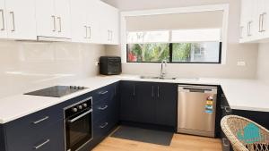 a kitchen with black and white cabinets and a sink at Castaway at Pelican in Pelican Flat