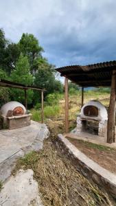 two stone ovens are sitting in a field at Kallpa Warmi in San Antonio