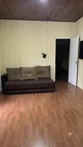 a couch sitting in a room with a wooden floor at Casa no Centro in Campo Largo