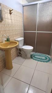 a bathroom with a toilet and a sink and a shower at Casa no Centro in Campo Largo