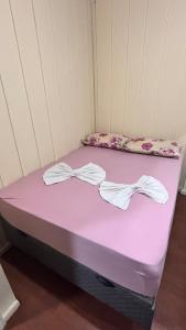 a purple bed in a room with bows on it at Casa no Centro in Campo Largo