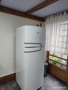 a white refrigerator in a kitchen with a window at Pousada Relicário in Nova Petrópolis