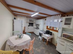 a kitchen with a table and a kitchen with white appliances at Pousada Relicário in Nova Petrópolis