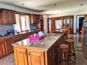 a kitchen with wooden cabinets and a pink basket on a counter at Moradia da Graça Guesthouse in Praia da Vitória