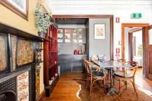 a dining room with a table and chairs and a fireplace at William Arnott Boutique Accommodation in Morpeth