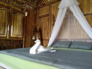 a bedroom with a bed with a mosquito net at Aska Bamboo House in Tampaksiring