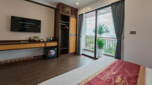 a bedroom with a bed and a large window at Pi Hotel Phố cổ Hoa Lư in Kỳ Vĩ