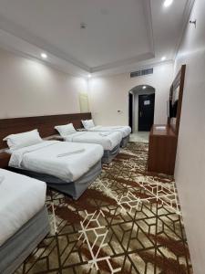 a row of beds in a room with a carpet at فندق فيفيان الجميزة in An Naqāʼ