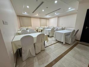 a room filled with tables and chairs with white table cloth at فندق فيفيان الجميزة in An Naqāʼ