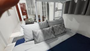 a couch with three pillows on it in a room at 338 Studio in Ban Liam
