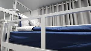 a bunk bed with blue sheets and a mirror at 338 Studio in Ban Liam