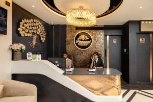 two people sitting at a reception desk in a lobby at Paramount Residency in Nedumbassery