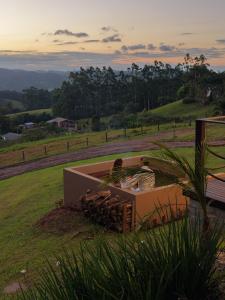 two people sitting in a box in a field at Caramelo Chalé in Rio do Sul