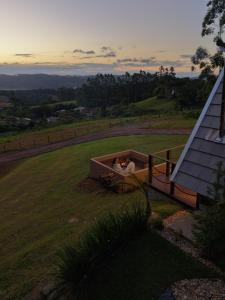 a bath tub with two people in it in a field at Caramelo Chalé in Rio do Sul