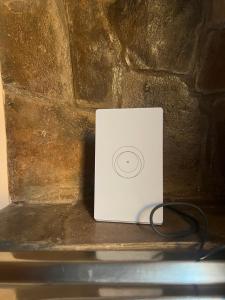 a white ipod sitting next to a stone wall at Cabañas Puesta del Sol in Purmamarca