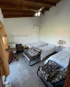 a room with three beds and a table in it at Posada La Martina in Goya