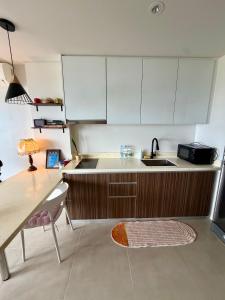 a kitchen with white cabinets and a sink and a table at Room in Maribago in Lapu Lapu City