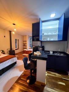 a kitchen with a sink and a bed in a room at Shoresh Araucária in Campos do Jordão