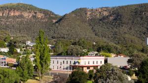 a large white building in front of a mountain at Kandos Hotel in Kandos