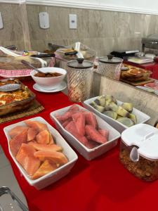 a table topped with trays of food on a red table at Pousada Oliveira in Remanso