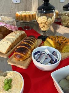 a table topped with lots of different types of bread at Pousada Oliveira in Remanso +4 photos