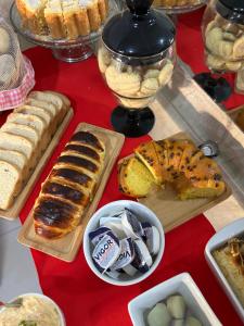 a table topped with different types of bread and desserts at Pousada Oliveira in Remanso