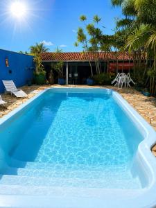 a large blue swimming pool in front of a house at LM Suítes in Búzios