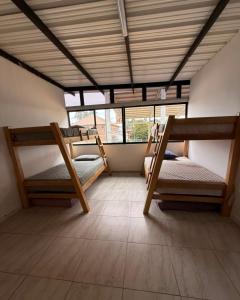 a room with three bunk beds in a room at Refugio raices in Guarne