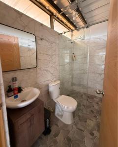 a bathroom with a toilet and a sink at Refugio raices in Guarne +3 photos