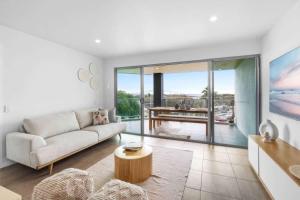 a living room with a couch and a table at Point Cartwright Penthouse - Ocean and River Views in Buddina