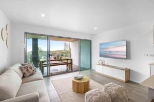 a living room with a couch and a table at Point Cartwright Penthouse - Ocean and River Views in Buddina