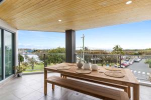 a dining room with a table and a large window at Point Cartwright Penthouse - Ocean and River Views in Buddina +20 photos