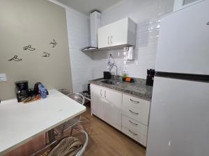 a kitchen with white cabinets and a white refrigerator at Studio Sudoeste Ed Multiparque in Brasília