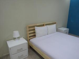 a bedroom with a bed and a night stand with a lamp at Yara Hotel in Punta Cana