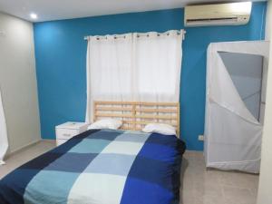 a blue bedroom with a bed and a window at Yara Hotel in Punta Cana