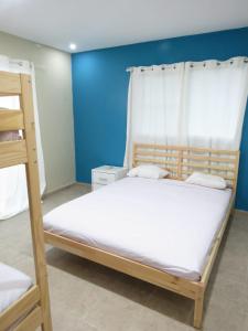 a bedroom with a bunk bed and a blue wall at Yara Hotel in Punta Cana