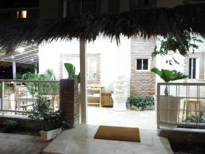 a patio with a straw umbrella and some plants at Yara Hotel in Punta Cana