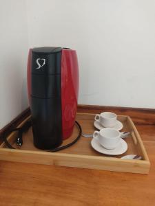 a coffee maker sitting on a tray with two cups at Prédio em praça pontal de Maceió in Fortim