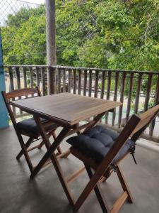 a wooden table and two chairs on a porch at Prédio em praça pontal de Maceió in Fortim