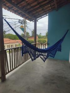 a hammock hanging from a porch with a fence at Prédio em praça pontal de Maceió in Fortim +9 photos