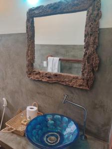 a bathroom with a blue sink and a mirror at Prédio em praça pontal de Maceió in Fortim