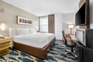 a hotel room with a bed and a desk and a television at Hotel Felix in Chicago