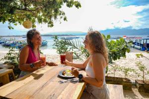 two women sitting at a table with a plate of food at Blue Marlin Dive Resort Trawangan in Gili Trawangan