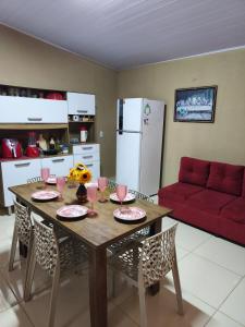 a kitchen with a wooden table and a red couch at Casa Refúgio na Serra, Tianguá in Tianguá